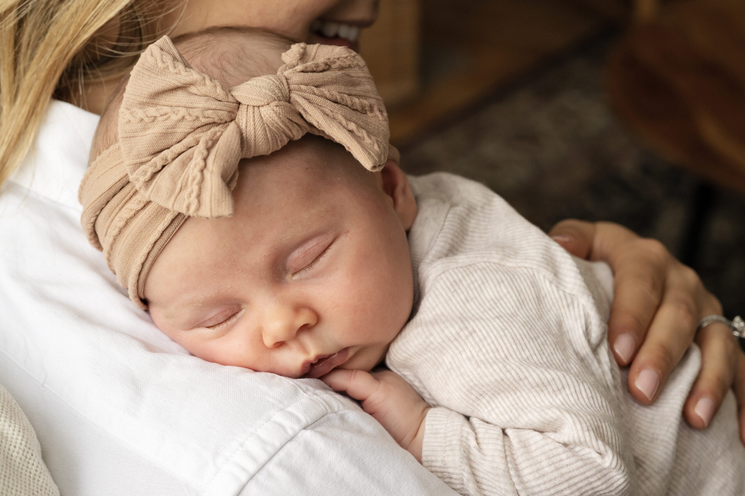 Newborn baby girl asleep on mothers shoulder during an at home newborn photo shoot in London