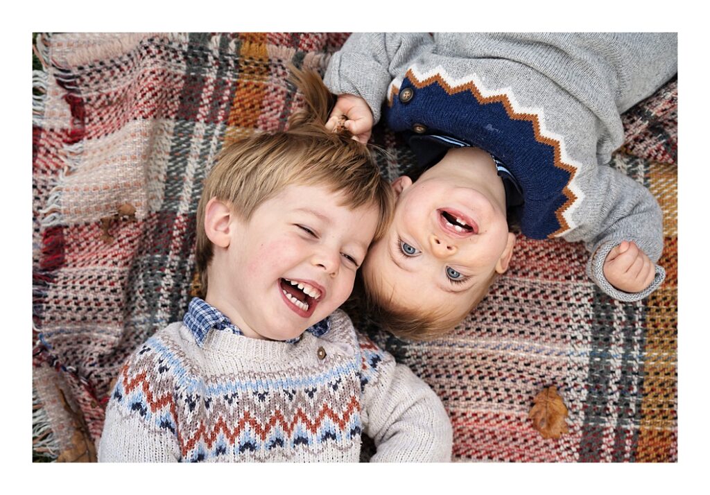 Two brothers laughing on a blanket