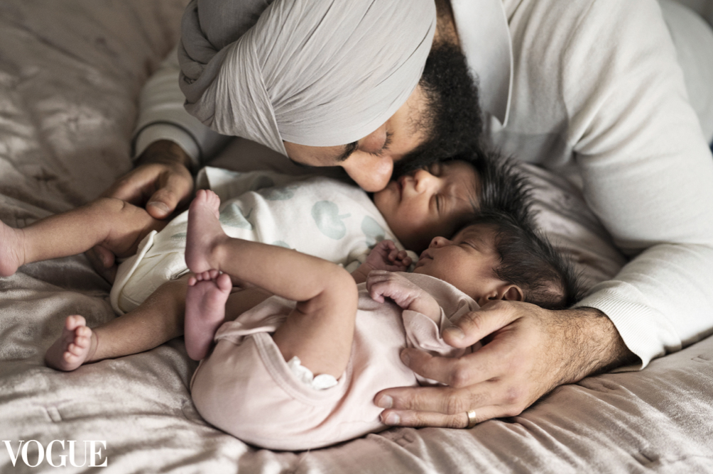 A father snuggles and breathes in his twin baby boy and girl as they sleep. This photograph was selected to be featured by Vogue Italia's Photo Vogue.