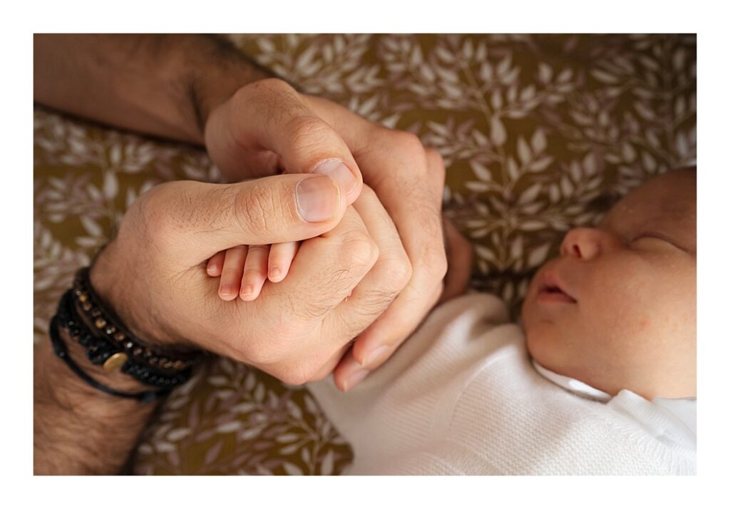 Father holds his baby's tiny hand