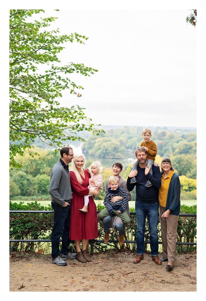 An extended family of 5 adults and 3 children pose for a photo on top of Richmond Hill